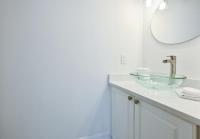 ein Badezimmer mit einem Glaswaschbecken und einem Spiegel in der Unterkunft Spacious+Cozy Home, near the beach, heated pool. in Naples