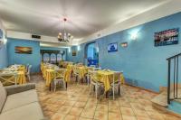 a restaurant with yellow tables and chairs and blue walls at Hotel Nice in Sorrento