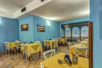 a restaurant with yellow tables and chairs and blue walls at Hotel Nice in Sorrento
