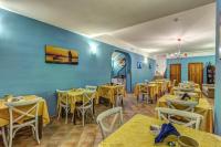 a restaurant with yellow tables and chairs and blue walls at Hotel Nice in Sorrento