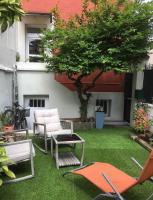 a lawn with chairs and a tree in a yard at Maison confortable avec jardin à 2 pas de Paris in Fontenay-sous-Bois