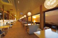 a restaurant with tables and chairs and a view of the ocean at GLAMPREMIER Setouchi in Kanonji
