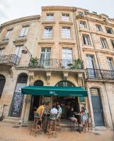 a group of people sitting at tables in front of a building at LOLA Boutique Hôtel - Bordeaux Centre in Bordeaux