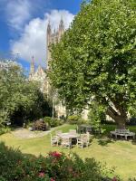 einem Park mit Tischen und Stühlen vor einem Gebäude in der Unterkunft Canterbury Cathedral Lodge in Canterbury