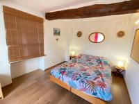 a bedroom with a bed with a colorful bedspread at 06AW - Mas en pierre provençal rénové au calme in Le Rouret