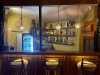 un bar con tres taburetes en un bar en Hotel Tharu Garden And Beer Bar, en Chitwan