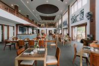 a restaurant with wooden tables and chairs at Ombak Sunset in Gili Trawangan