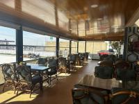 un ristorante con tavoli e sedie e una grande finestra di NUS GRAND HOTEL a Çatalözü