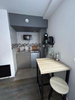 a small kitchen with a table and a counter top at Charmant studio au bord du lac d’Elancourt village in Élancourt