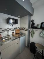 a small kitchen with a sink and a microwave at Charmant studio au bord du lac d’Elancourt village in Élancourt