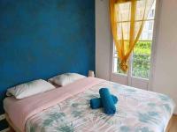 a bedroom with a bed with a blue wall and a window at Appartement Disney Paris in Serris