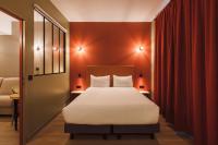 a bedroom with a bed and a red wall at Hôtel de Noailles in Lyon