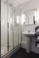 a bathroom with a glass shower and a sink at Hôtel de Noailles in Lyon