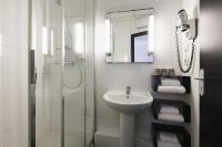 a white bathroom with a sink and a shower at Hôtel de Noailles in Lyon