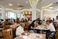 un gruppo di persone sedute ai tavoli di un ristorante di Dragon Sea Hotel a Sầm Sơn