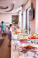 una linea a buffet con persone che preparano il cibo in un ristorante di Dragon Sea Hotel a Sầm Sơn