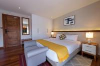 a bedroom with a large bed and a chair at Deerpark Luxury Stays in Nairobi