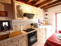 a kitchen with white cabinets and a stove top oven at Gîte Sansac-Veinazès, 3 pièces, 4 personnes - FR-1-742-114 