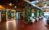 a dining room with white tables and plants on the walls at GP House Phuket Patong Beach in Patong Beach
