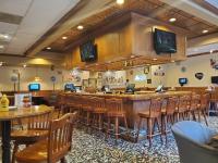 un restaurant avec un bar avec des chaises et des téléviseurs dans l'établissement Ramada by Wyndham State College Hotel & Conference Center, à State College