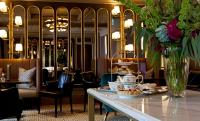 a dining room with a table with a vase of flowers at The Gainsborough Bath Spa - Small Luxury Hotels of the World in Bath