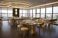 艾卜哈Best Western Plus Danat Almansak Hotel的一家有桌椅和窗户的餐厅