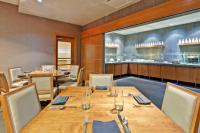 a restaurant with wooden tables and chairs and a counter at Crowne Plaza Chicago O'Hare Hotel & Conference Center by IHG in Rosemont
