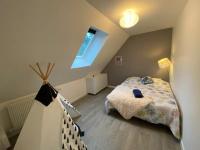a small attic bedroom with a bed and a window at Maison au calme dominant la ville d&#39;Evreux in Évreux