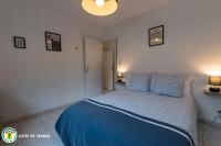 a bedroom with a blue bed with two pillows at L&#39;Appart de La Goutte d&#39;Or in Avize