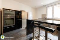 a kitchen with a stove and a counter with stools at L&#39;Appart de La Goutte d&#39;Or in Avize