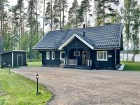 une petite maison bleue avec une allée en gravier dans l&#39;établissement Saimaan Villa Mustikka, à Äitsaari