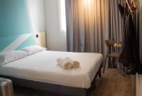 une chambre d&#39;hôtel avec un lit et des serviettes. dans l&#39;établissement ibis budget Lunel Porte de Camargue, à Aimargues