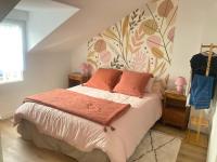 a bedroom with a large bed with orange pillows at Manava Villa vue mer et Mont Saint Michel piscine intérieure in Saint-Jean-le-Thomas