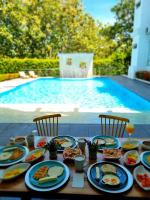 a table with plates of food next to a swimming pool at Hotel Puerto Triunfo in Doradal