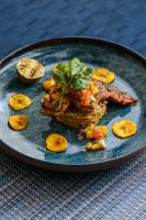 Un plato de comida con carne y verduras en una mesa. en Wymara Resort & Villas, en Grace Bay