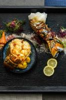 Una bandeja con un plato de comida con camarones y otros alimentos. en Wymara Resort & Villas, en Grace Bay