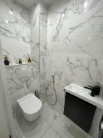 a white bathroom with a toilet and a sink at Appartement moderne de 2 pièces in Suresnes