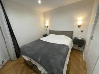 a small bedroom with a bed and two night stands at Appartement moderne de 2 pièces in Suresnes