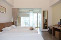 a hotel room with three beds and a balcony at Luminous Hot Spring Resort &amp; SPA in Luye