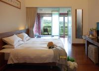 a bedroom with a large bed with a teddy bear on it at Luminous Hot Spring Resort &amp; SPA in Luye