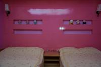 a pink room with two beds and shelves at See Starsea Guest House in Magong