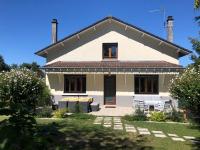 a white house with a blue sky in the background at Les Beaux Sapins 2 in Rochechouart