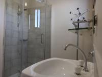 a bathroom with a shower and a white sink at Les Beaux Sapins 2 in Rochechouart