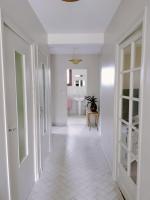 a hallway with white walls and white floors and doors at Les Beaux Sapins 2 in Rochechouart