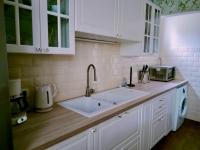 a white kitchen with a sink and a microwave at Les Beaux Sapins 2 in Rochechouart