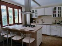 a kitchen with white cabinets and a large island with stools at Les Beaux Sapins 2 in Rochechouart