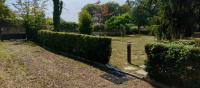 a hedge in a yard with a fence at Les Beaux Sapins 2 in Rochechouart