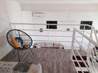 Habitación con silla y escalera en Appartement Mezzanine, en Fort-de-France