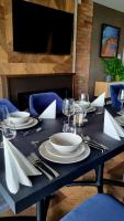 a black table with white plates and silverware on it at Hotel Kőporos Hercegkút in Hercegkút