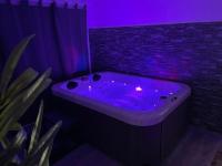 a bath tub with purple lights in a bathroom at La Paillote Exotique Spa in Beaucaire